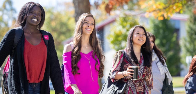 Students smiling and walking on campus