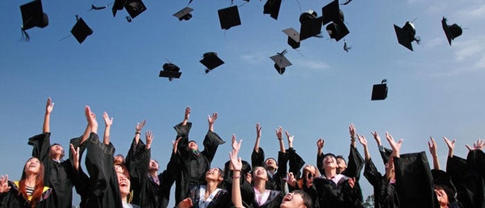 graduates throwing their caps into the air