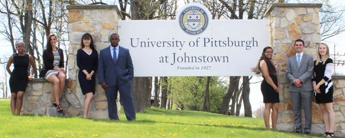 group of people standing next to Pitt Johnstown sign