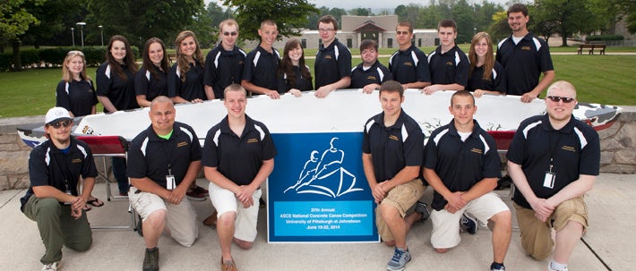 group of students standing next to a boar