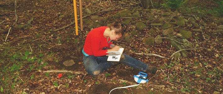 student writing in the woods