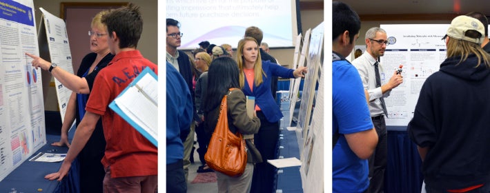 Looking at informational posters at the Fall into Research symposium