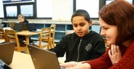 adult showing a child something on a computer