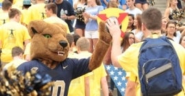 student high-fiving Pitt's mascot