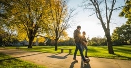 two people walking down a path on a sunny day