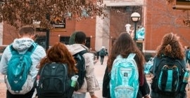 students with backpacks walking 