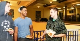 Three students talking and eating food