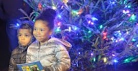 children standing next to Christmas tree