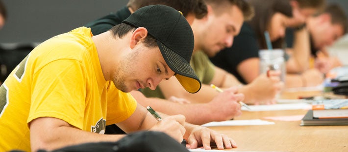 student writing in a classroom