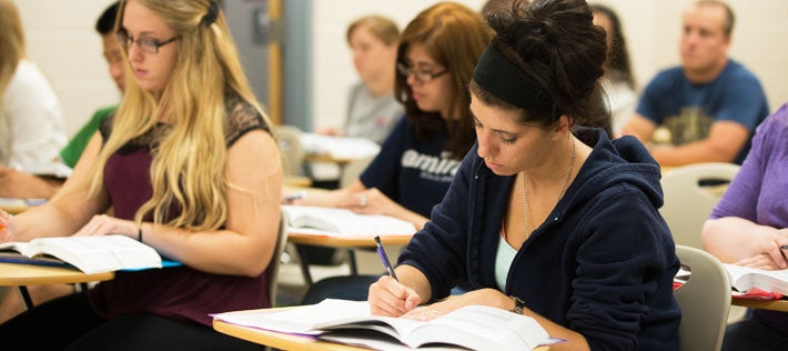 students writing in a classroom