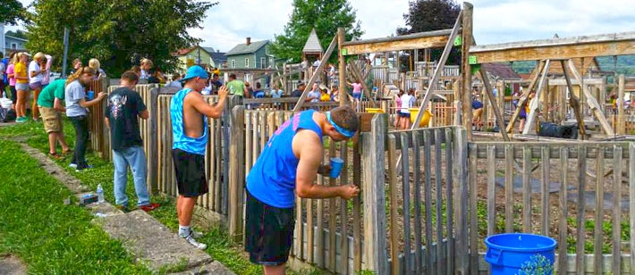 volunteers painting a fence